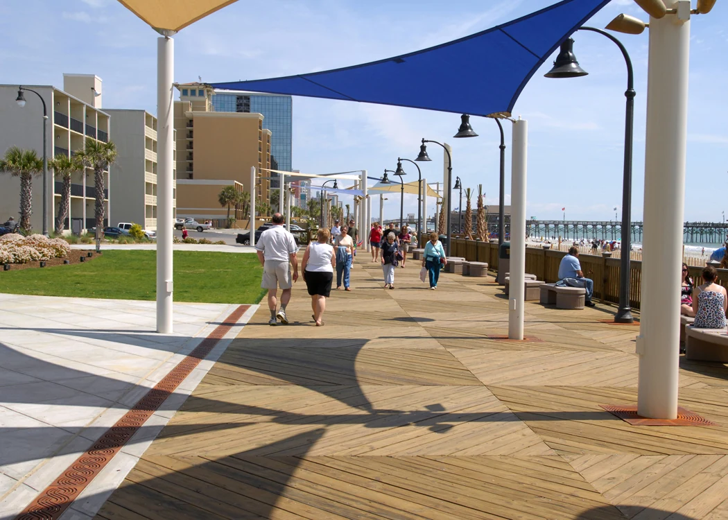 Myrtle Beach Boardwalk with shade sails, pedestrians, and the ocean