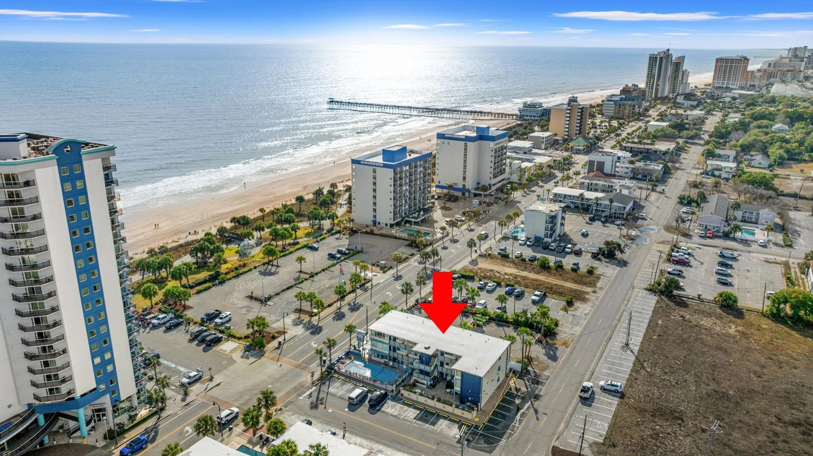 Hotel marked with a red arrow in the supplied coastal aerial